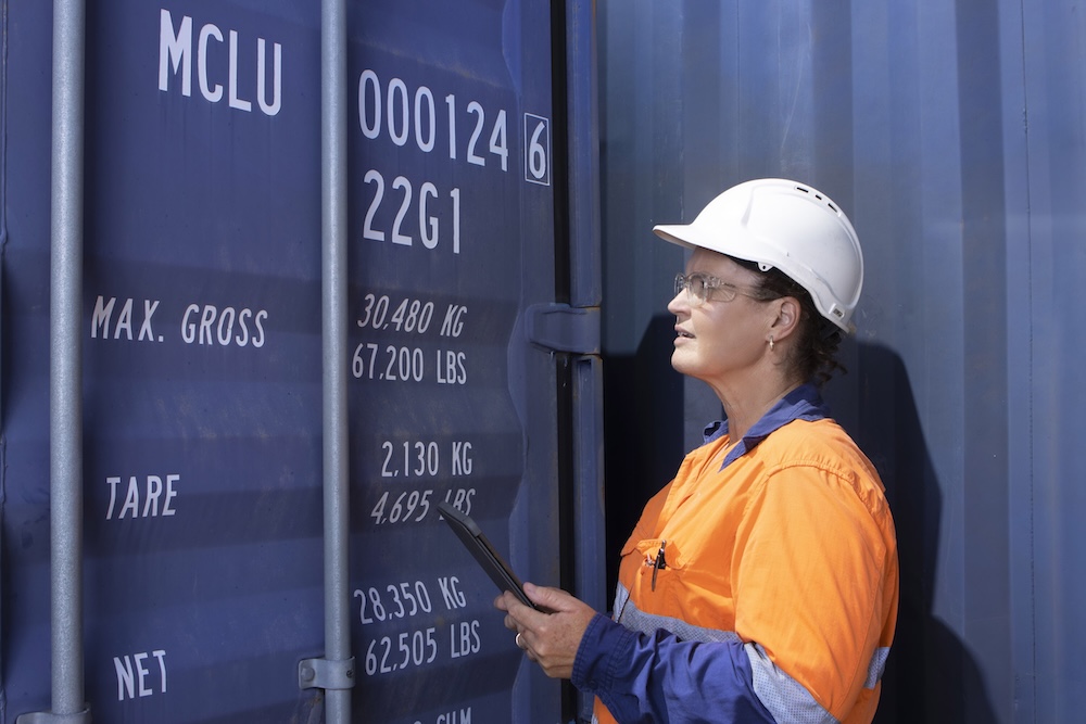 BSQC inspector in hi-vis gear examining a sea container door during a quarantine compliance inspection